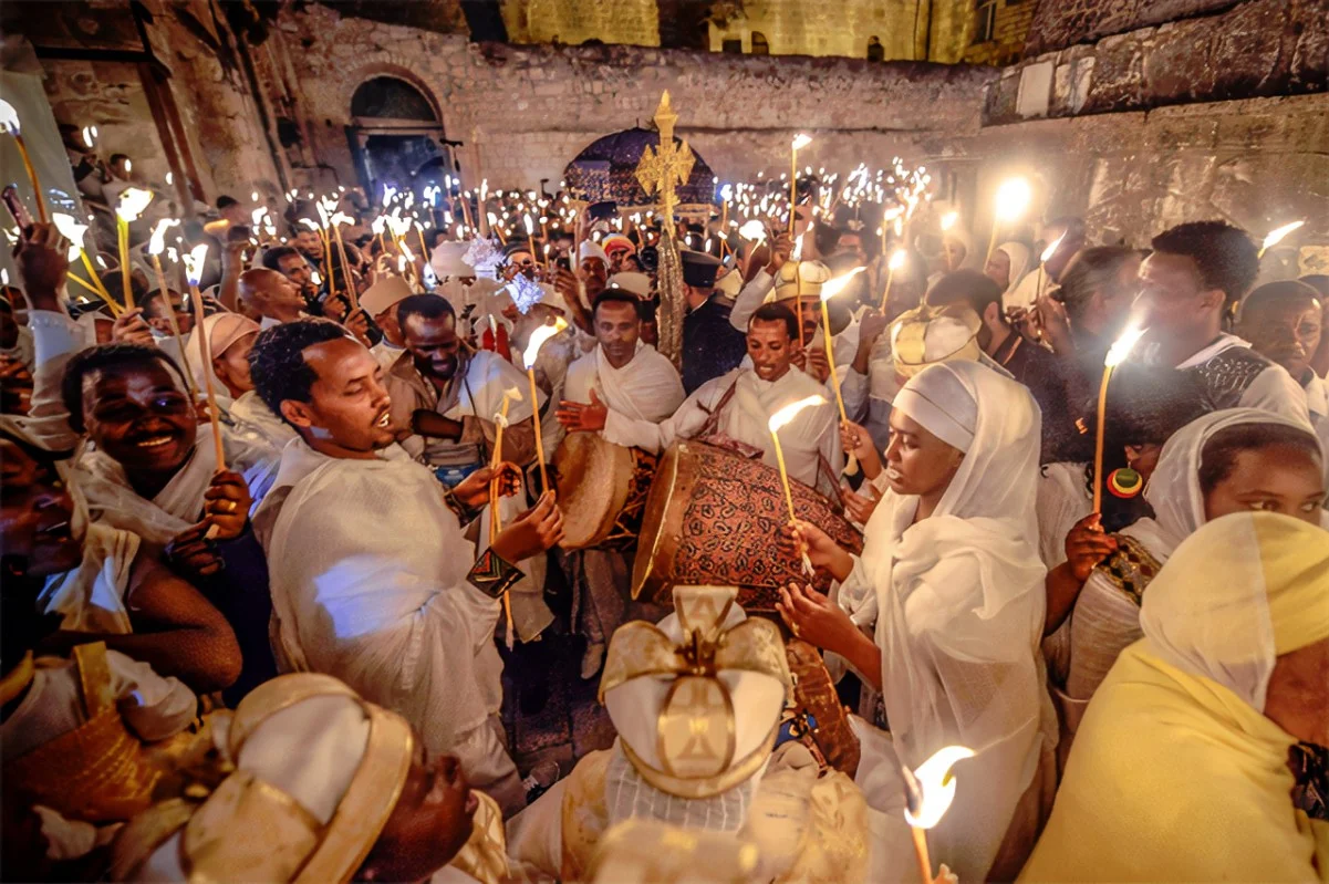 Close-up of joyful worshippers holding lit candles during the Fasika Easter celebration in Ethiopia