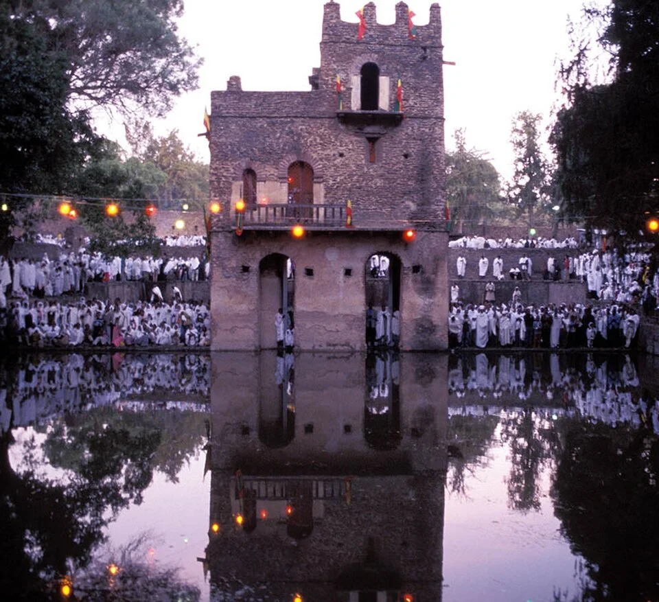 A stone arch framing the historic ruins of Gondar, Ethiopia