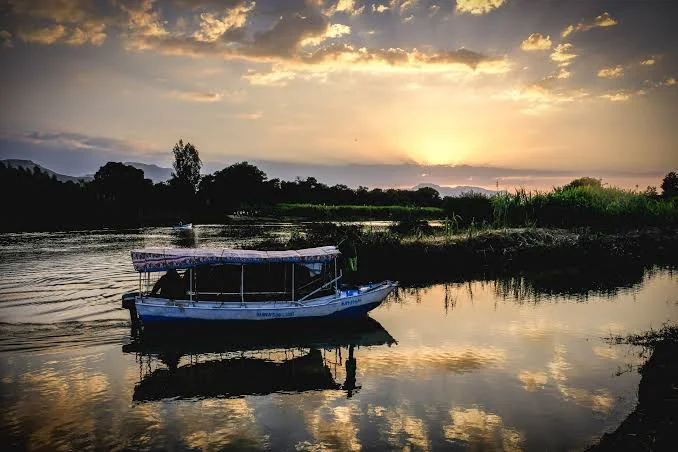 A boat cruising on Lake Tana at sunset near Bahir Dar, Ethiopia