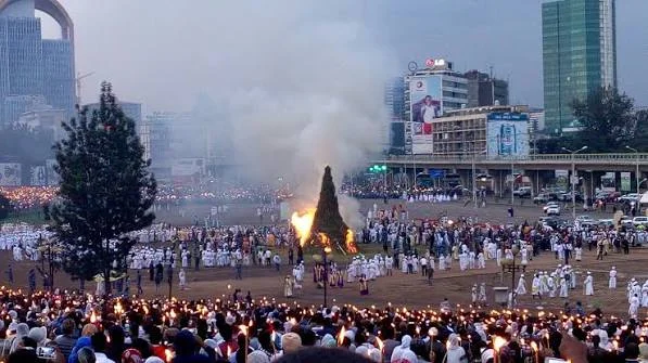 Torchlit crowd gathered around the burning Demera bonfire at dusk during Meskel in Addis Ababa